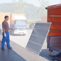 Mann lässt federunterstützte Aluminium-Klappbrücke mit Fallsicherung herunter