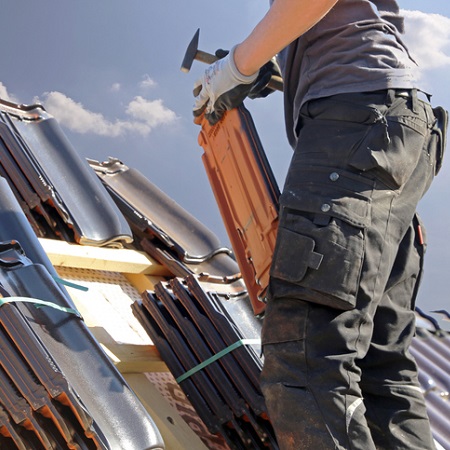 Dachdecker mit Werkzeug auf dem Dach