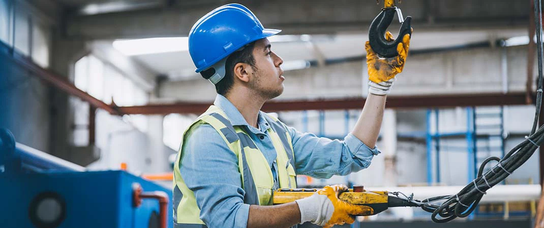 Mann überprüft Anschlagmittel im Lager