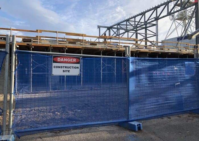 Bauzaun mit Sichtschutz und Warnschild um eine Baustelle aufgestellt