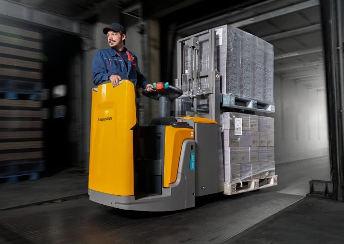 Lagermitarbeiter entlädt Lkw mit Hochhubwagen im Cross-Docking-Zentrum