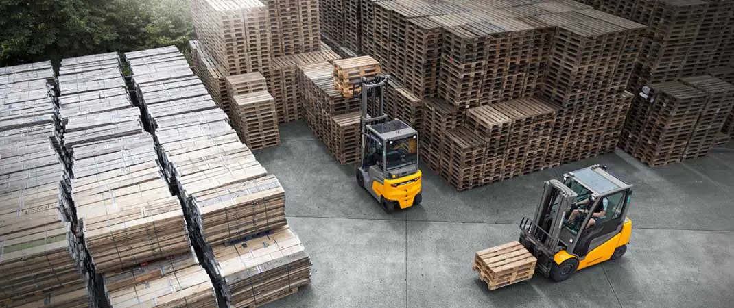 Gabelstapler Maße im Einsatz: Zwei Gabelstapler transportieren Paletten im Außenlager