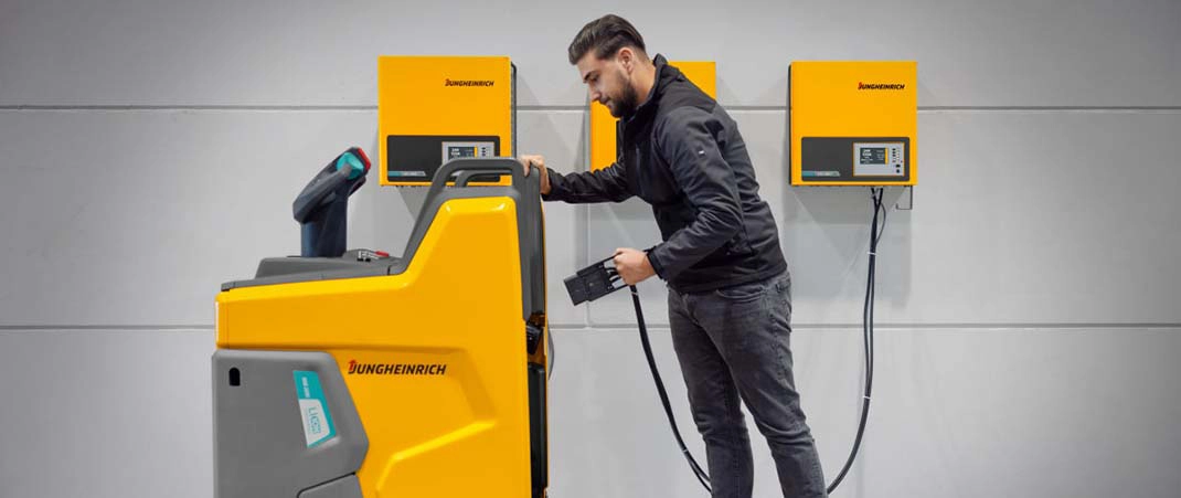 Mitarbeiter lädt ein Flurförderzeug mit Batterieladeanlagen für Flurförderzeuge an einer Wandladestation