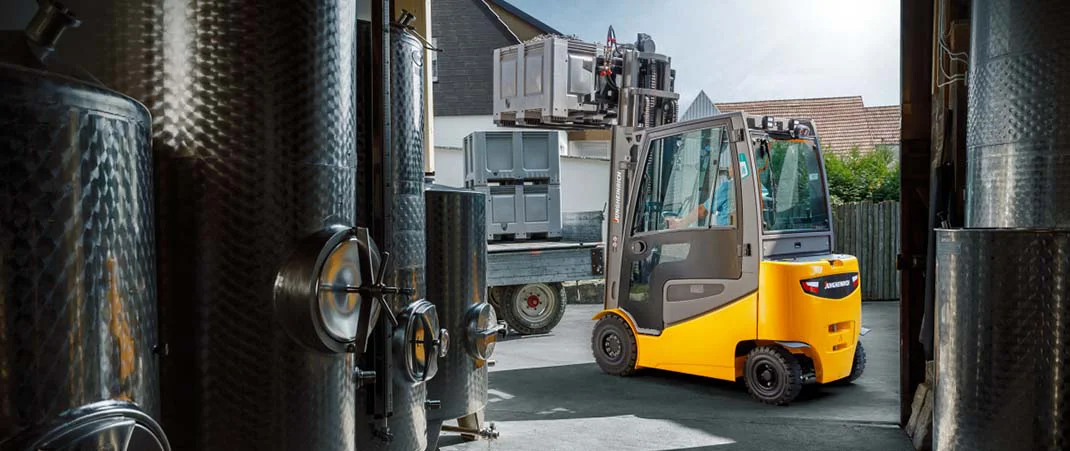 Ein LKW wird vor einer Brauerei mit einem Gabelstapler beladen