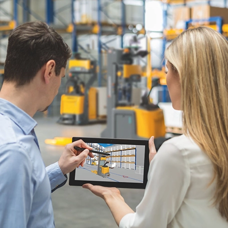 Zwei Personen entwerfen im Lager am Tablet ein Lagerkonzept