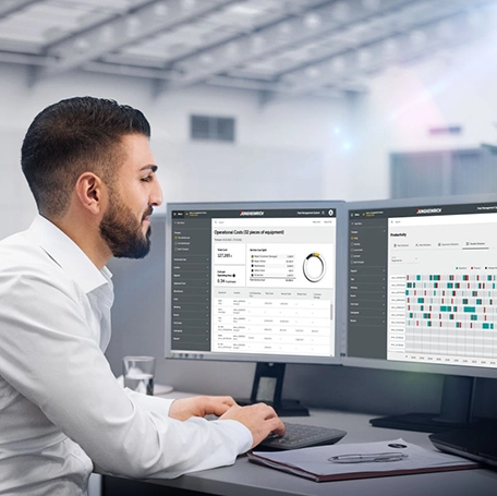 Ein Büromitarbeiter überwacht und optimiert die umgesetzte neue Lagerplanung am PC